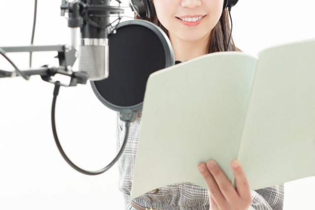 声優がマイクに声を吹き込んでいる画像