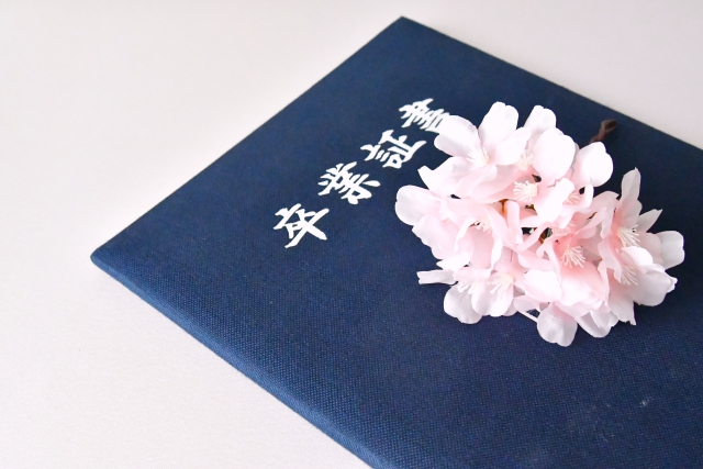 卒業証書と桜の画像